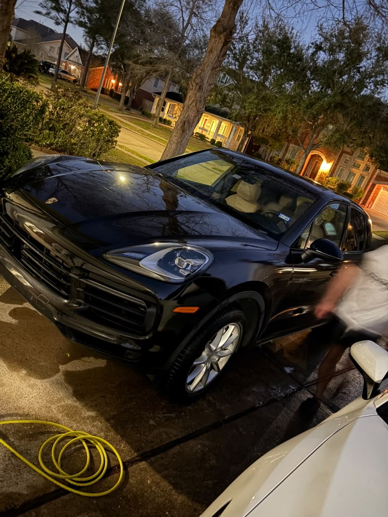 Black luxury SUV being washed at night